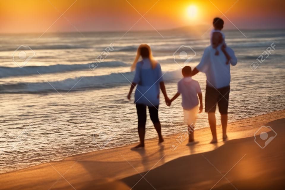 Riunioni di famiglia e socializzazione sulla spiaggia al tramonto. la famiglia cammina lungo la spiaggia sabbiosa. fuoco selettivo