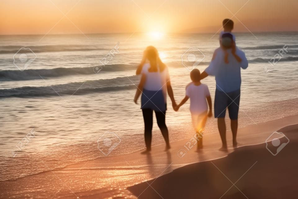 Reuniones familiares y socialización en la playa al atardecer. la familia camina por la playa de arena. enfoque selectivo