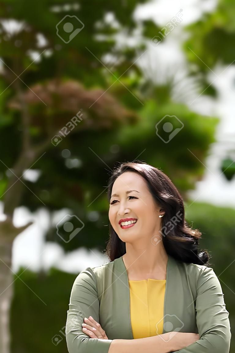 Portrait of beautiful smiling mature woman in the park