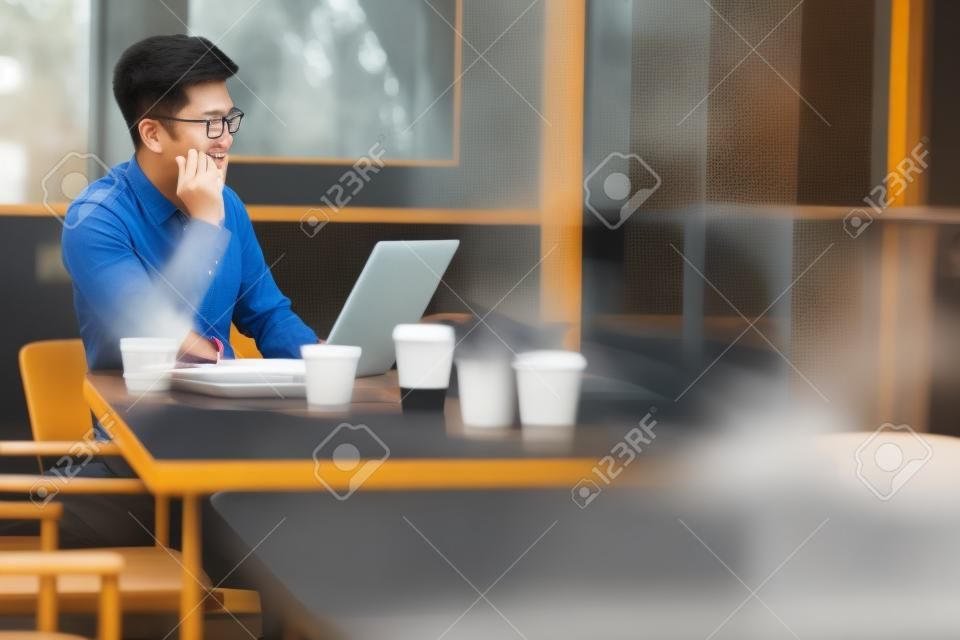 Asiatin studentin am laptop im café