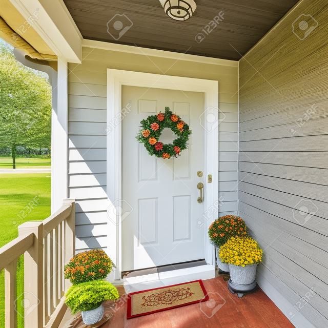 Vierkant frame Voordeur veranda met decoratieve displays van bloemen krans en potted bloemen op de vloer