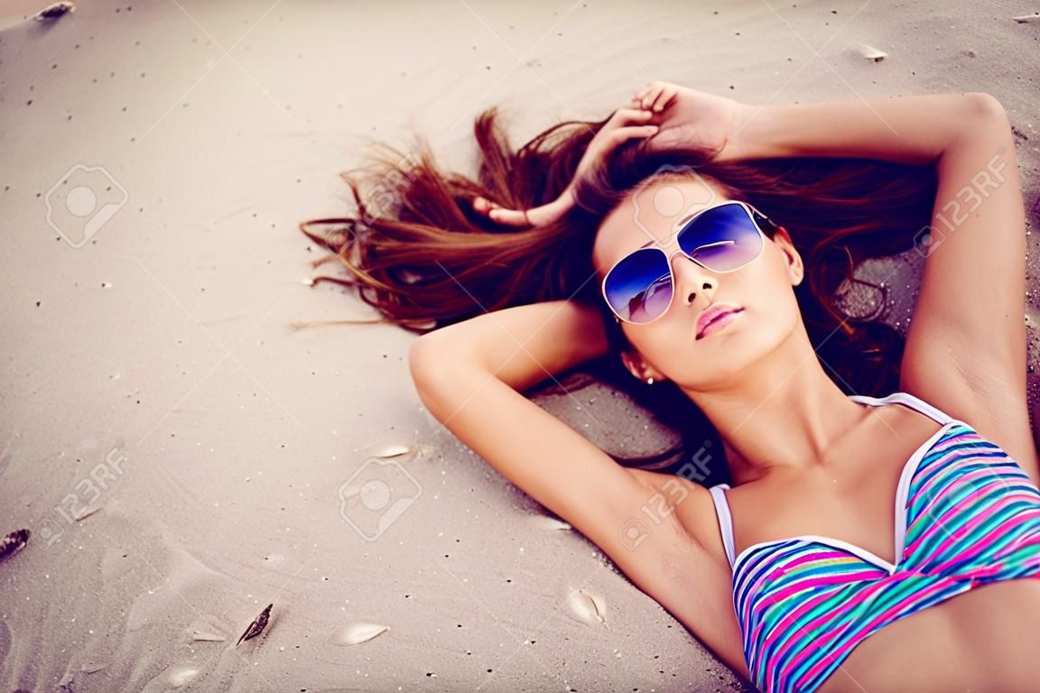 Beautiful model relaxing on the beach