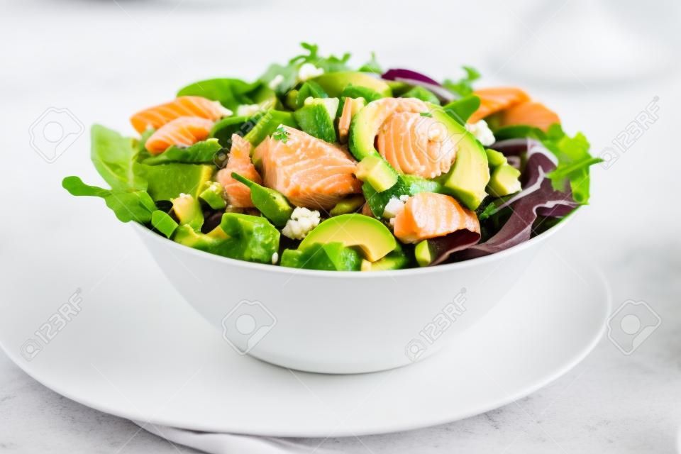 Gesunder grüner Salat mit Lachsfisch und Avocado lokalisiert auf Weiß