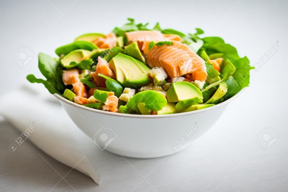 Healthy green salad with salmon fish and avocado isolated on white 