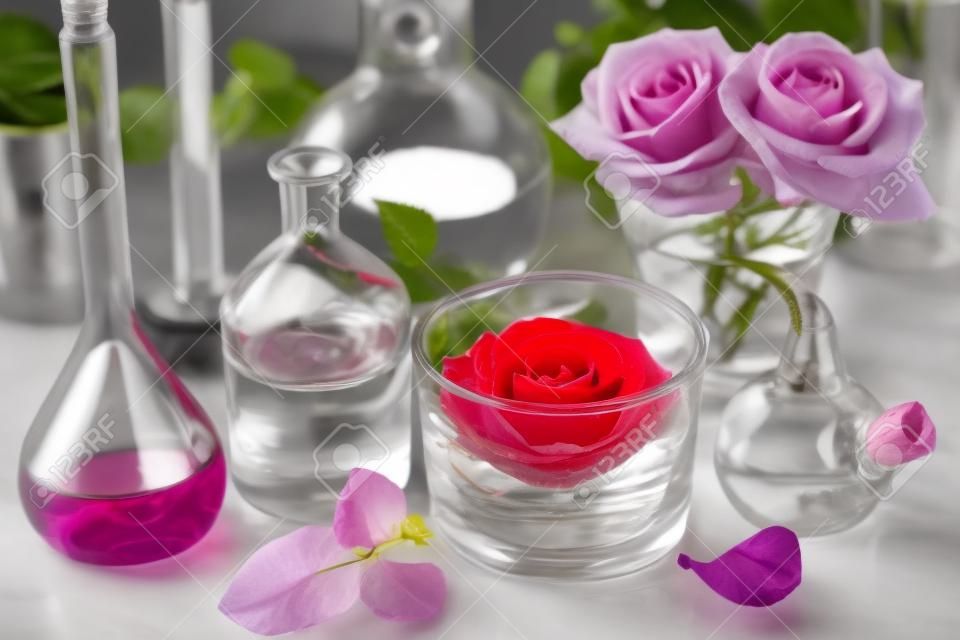 alquimia y aromaterapia establecen con flores rosas y frascos de químicos