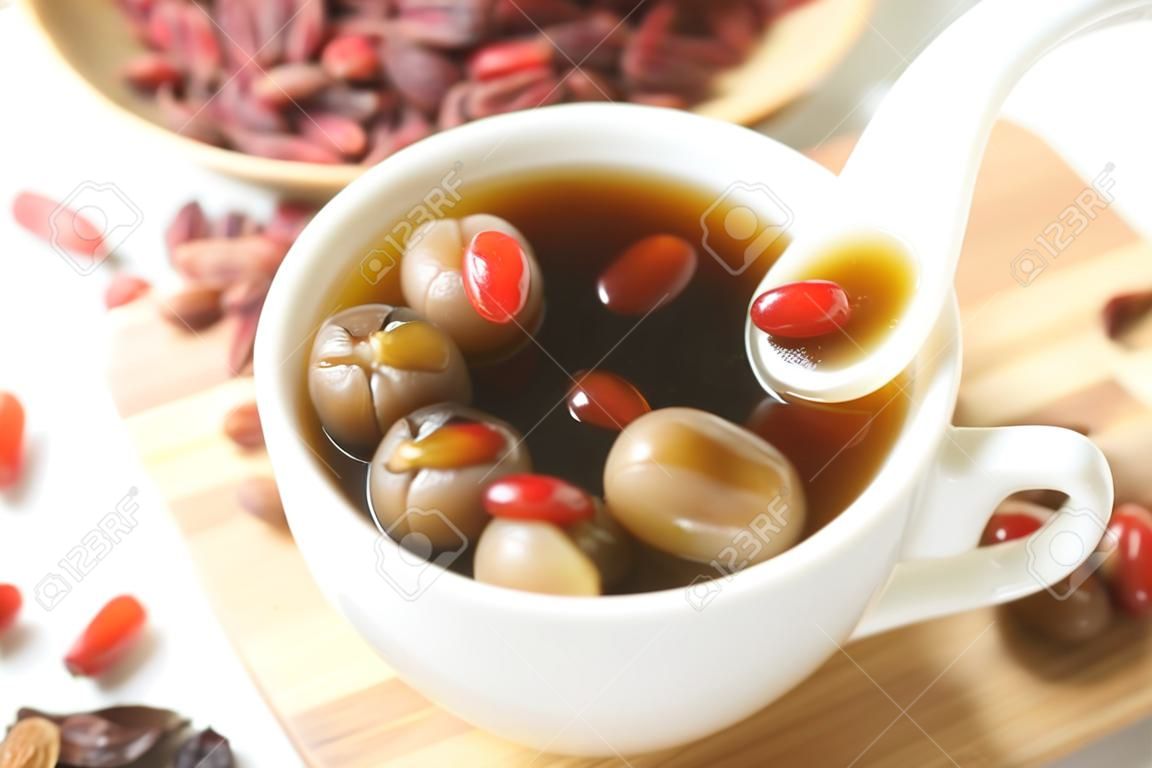 Wolfberry jujube tea longan в чашке чая на деревянном подносе
