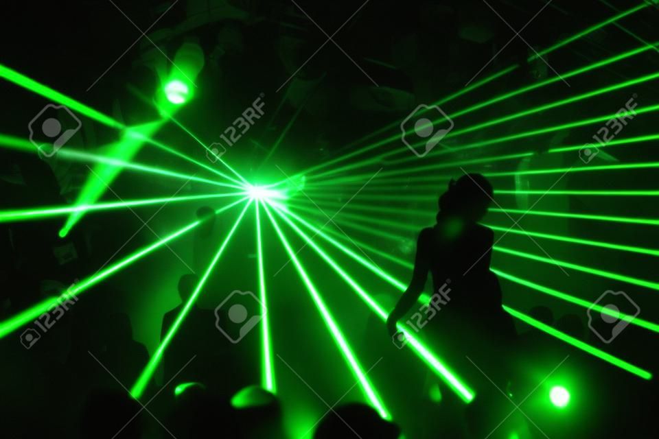 silhouette of dancing woman between green laser light