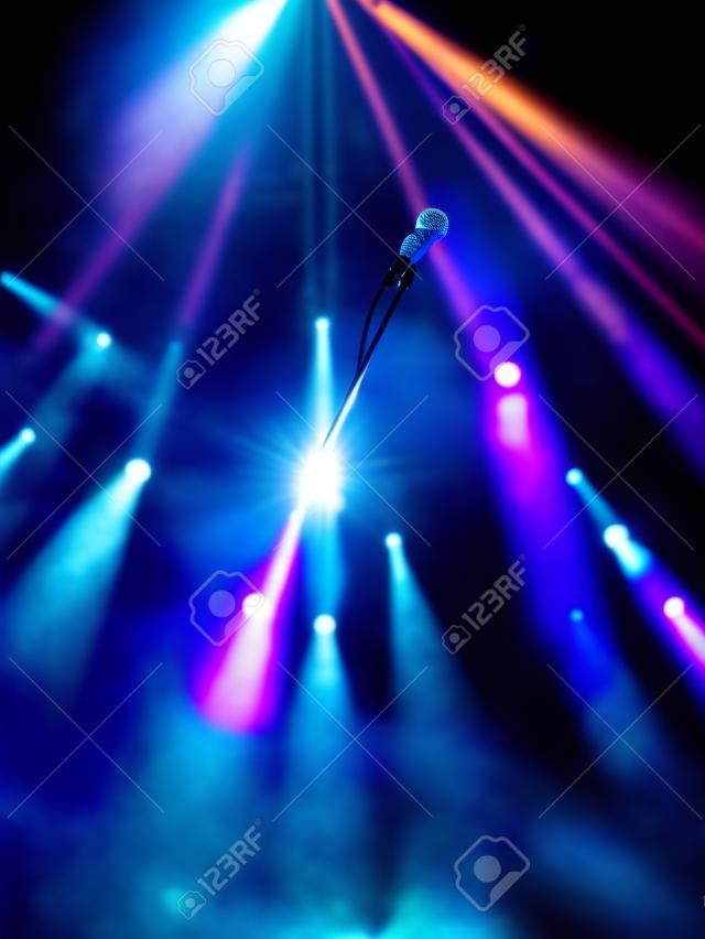 Arka planda sahne ışıkları ile sahnede mikrofon
