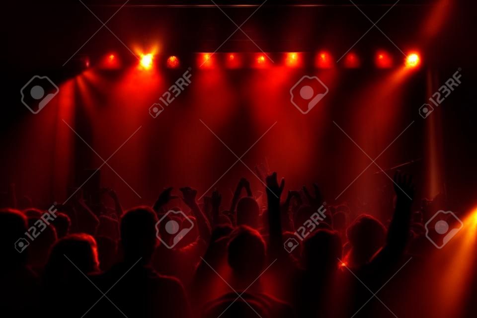 sagome di folla concerto davanti a luci palco luminoso