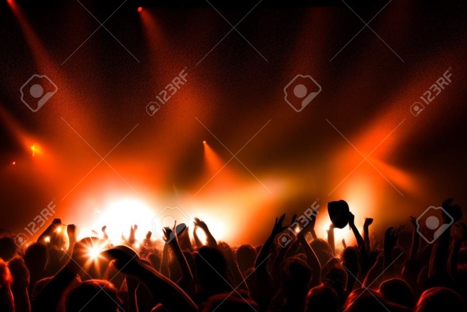 parlak sahne ışıkları önünde konser kalabalık siluetleri