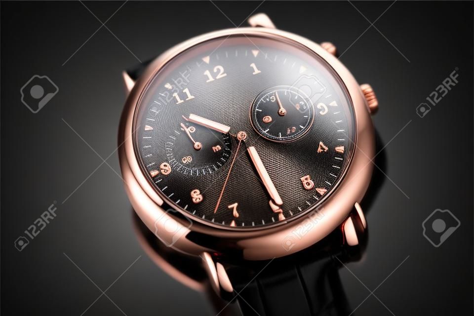 Elegant copper wristwatch with black dial on black background