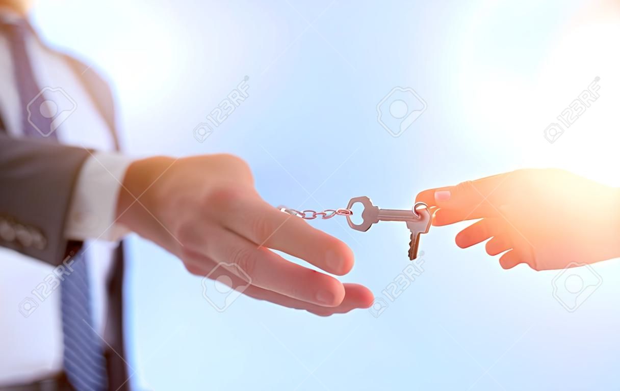 Immagine potata dell'agente immobiliare che fornisce le chiavi della casa all'uomo in ufficio