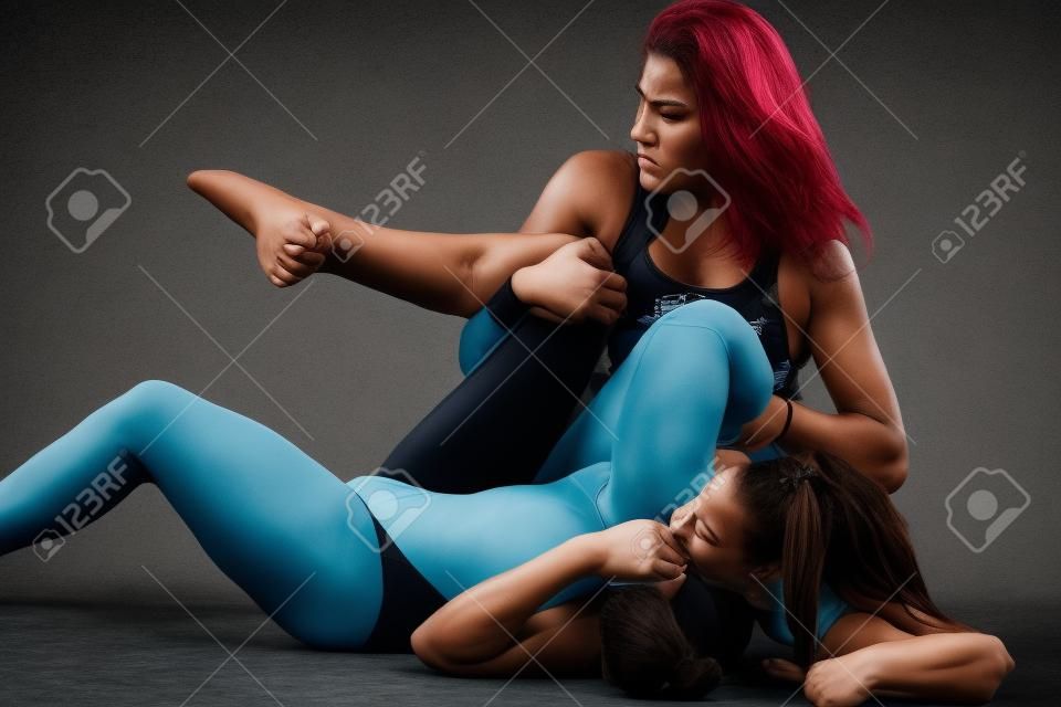 dos mujeres que luchan con la lucha libre sostiene sobre fondo gris