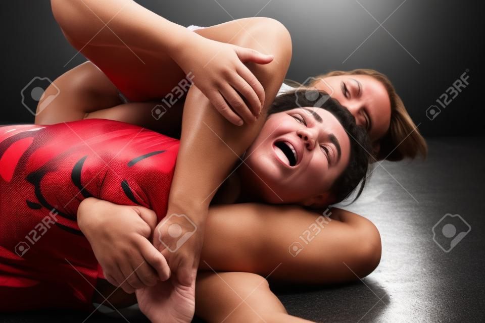 zwei Frauen kämpfen - schmerzhafte Ringen Bein Schere halten