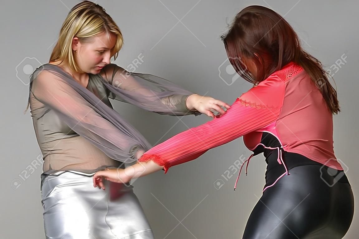 dos chicas peleando y tirando de vestidos