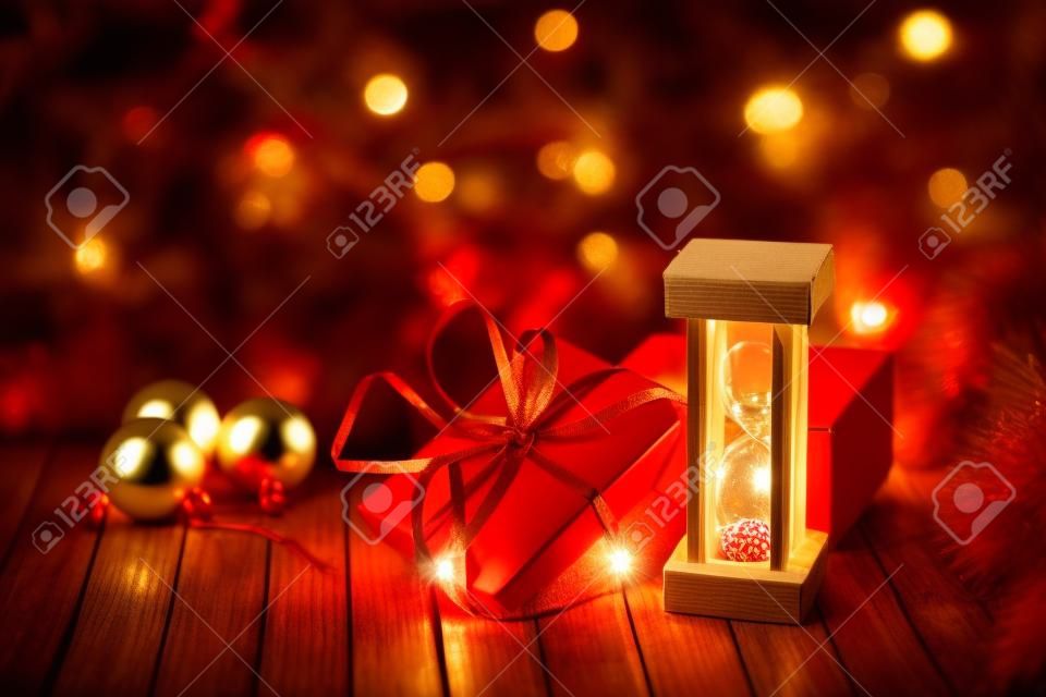 Sablier et boîte en carton sur une table en bois décorée d'une guirlande et de boules de Noël rouges pour le Nouvel An ou XMAS. Concept de service de courrier, de messagerie ou de livraison. Copiez l'espace.