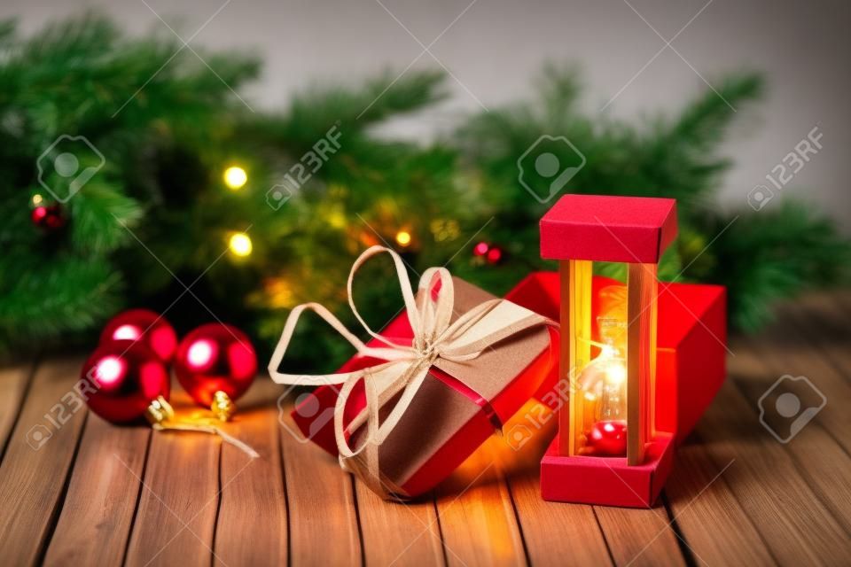 Sablier et boîte en carton sur une table en bois décorée d'une guirlande et de boules de Noël rouges pour le Nouvel An ou XMAS. Concept de service de courrier, de messagerie ou de livraison. Copiez l'espace.
