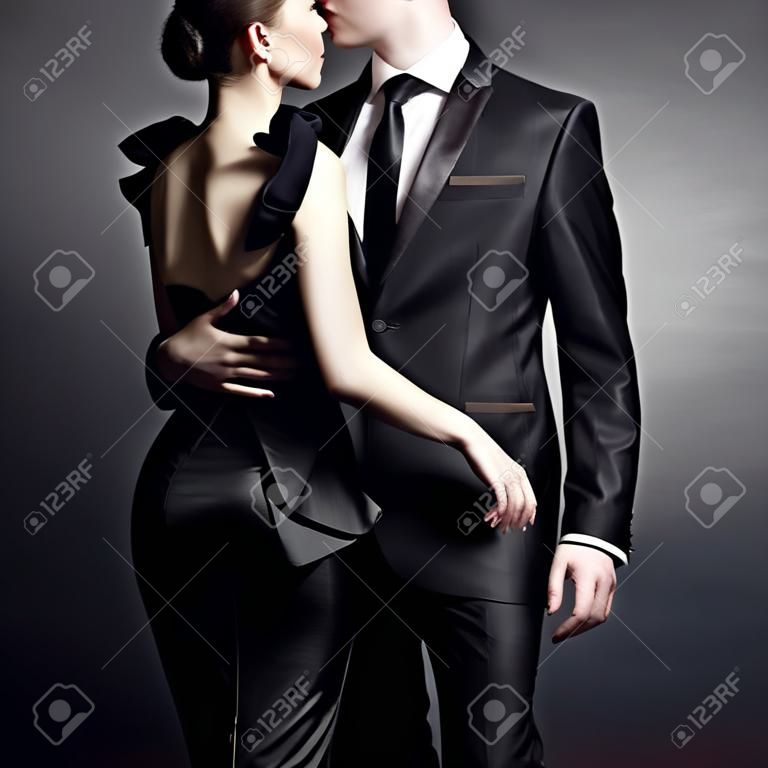 Концептуальный портрет молодой пары в элегантных вечерних платьях