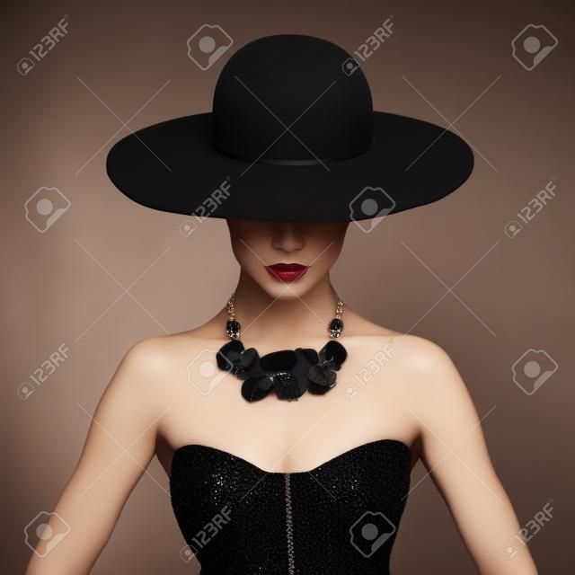 美麗的女人在優雅的黑色帽子時尚寫真