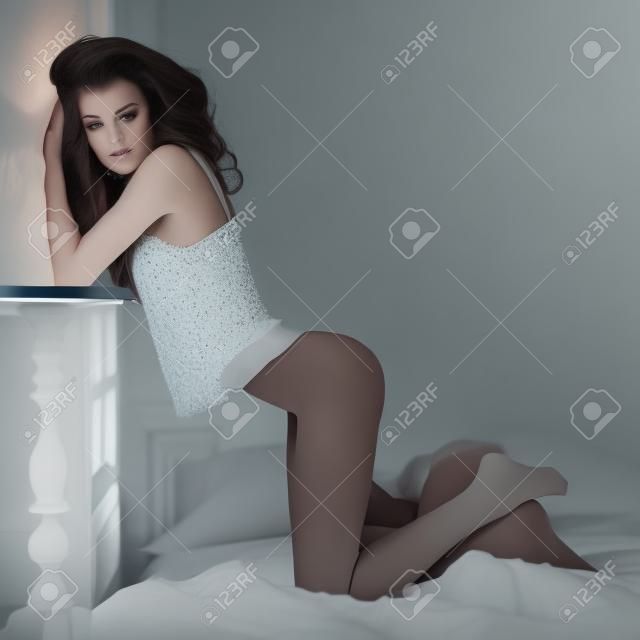 Fashion portrait of young elegant woman in bed