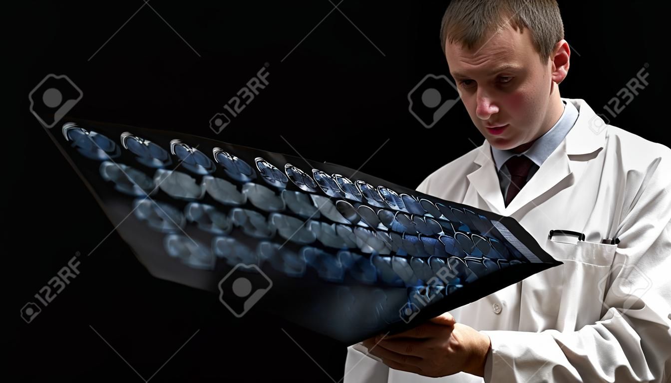 concetto Il paziente oncologico, la donna calva e l'uomo medico stanno visualizzando i risultati della tomografia su sfondo nero.