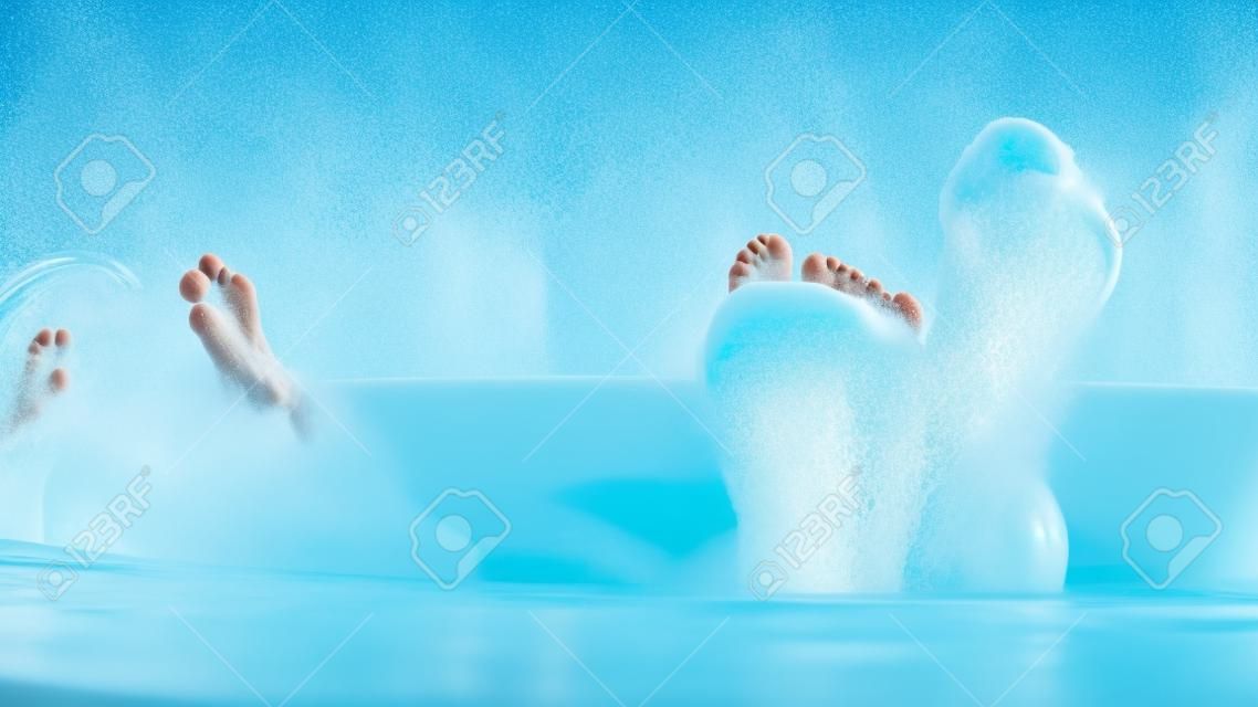 male feet of bath water. handsome man dancing with his feet while taking a bath with extensive foam
