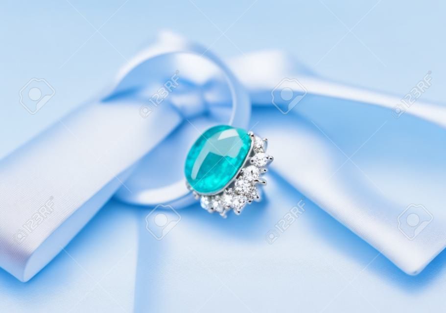 Anello di elegante gioielli con pietre gioiello su uno sfondo di prua setosa