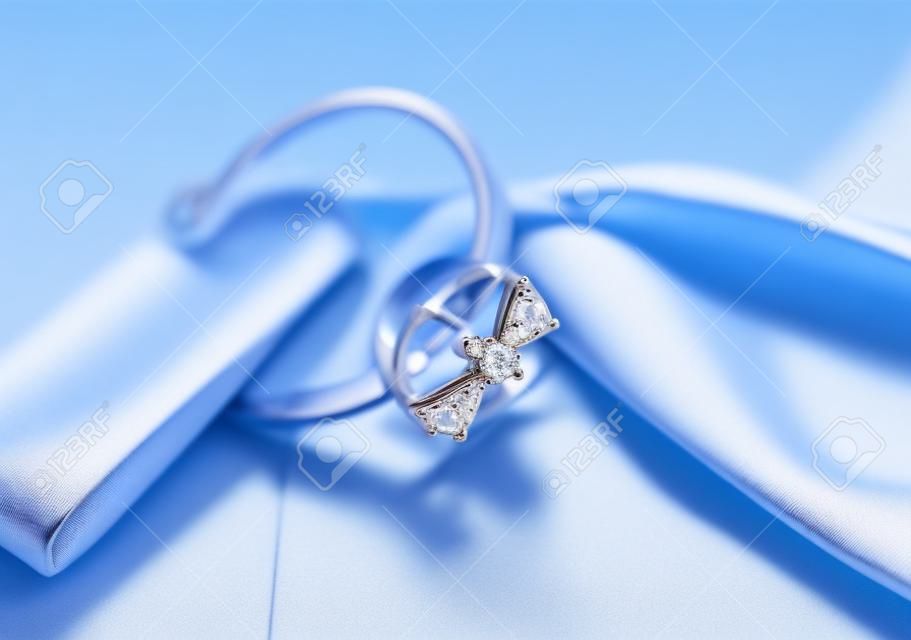 Anello di elegante gioielli con pietre gioiello su uno sfondo di prua setosa