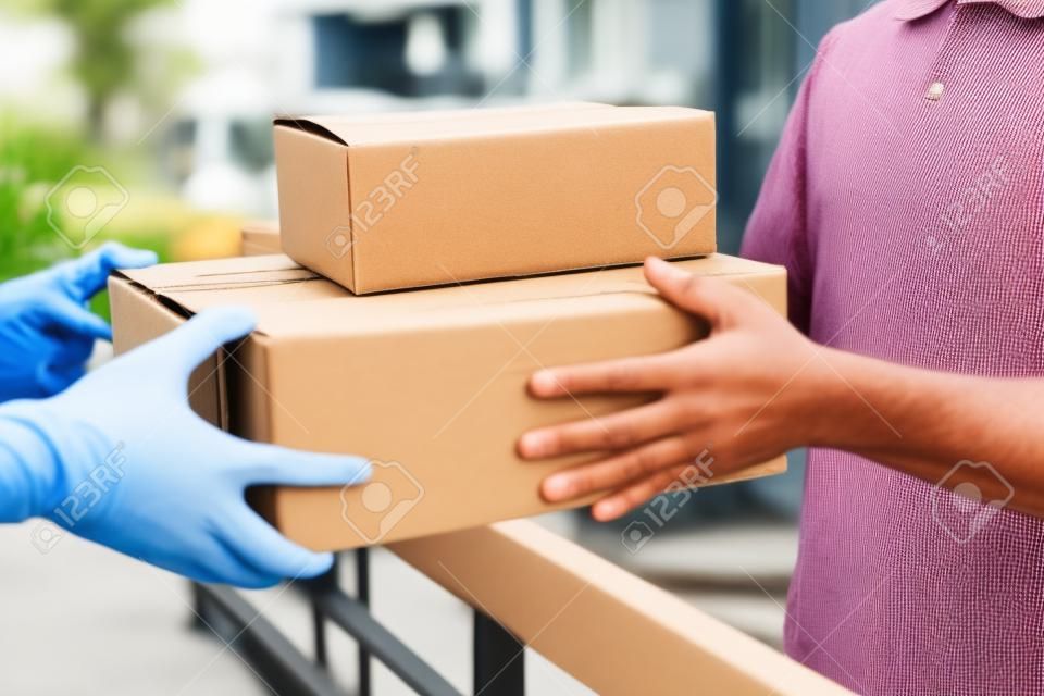 受取人に小包箱を与える配達メールマン、若い所有者は、ポスト出荷から段ボール箱パッケージを受け入れ、宅配便と配達サービスマインドコンセプト。