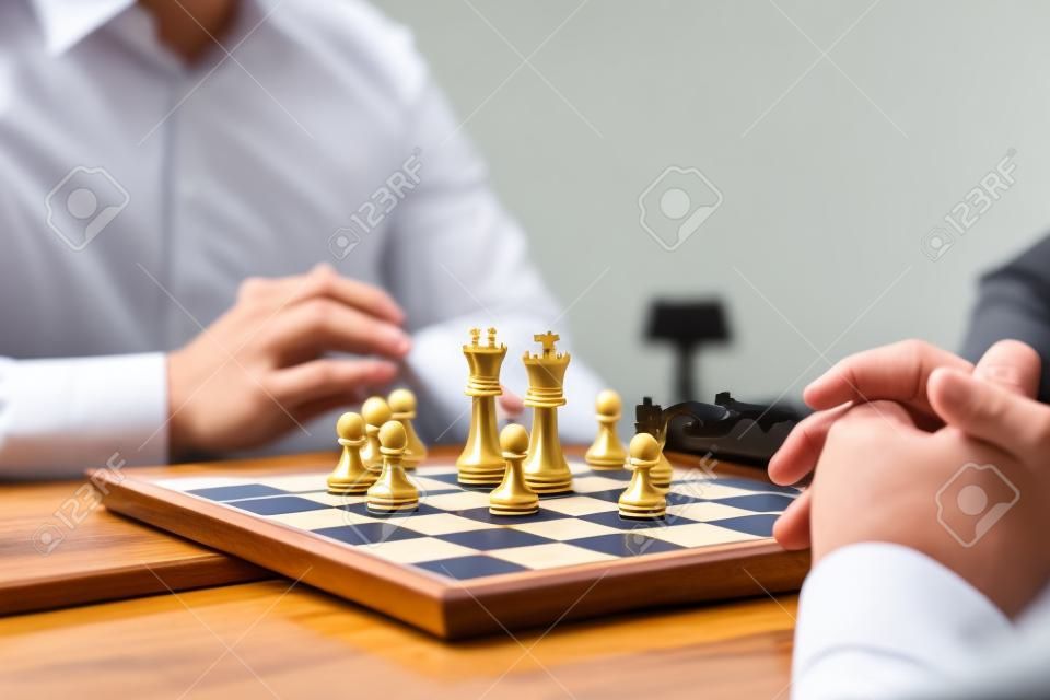 Intelligent businessman playing chess game competition with the opposite team, planning business strategic to development for win and success, Gold and silver chess with player.
