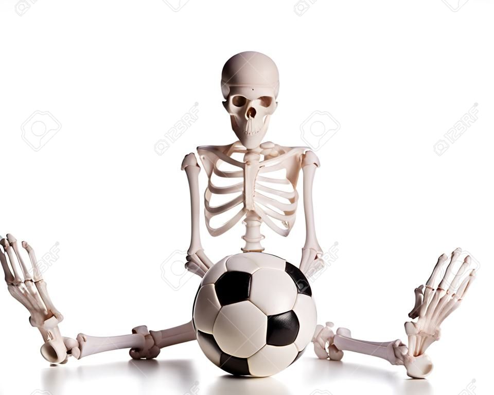 Skeleton mit Fußball auf dem weißen isoliert