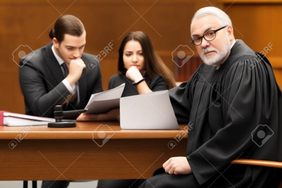 Young woman in courthouse with judge and lawyer