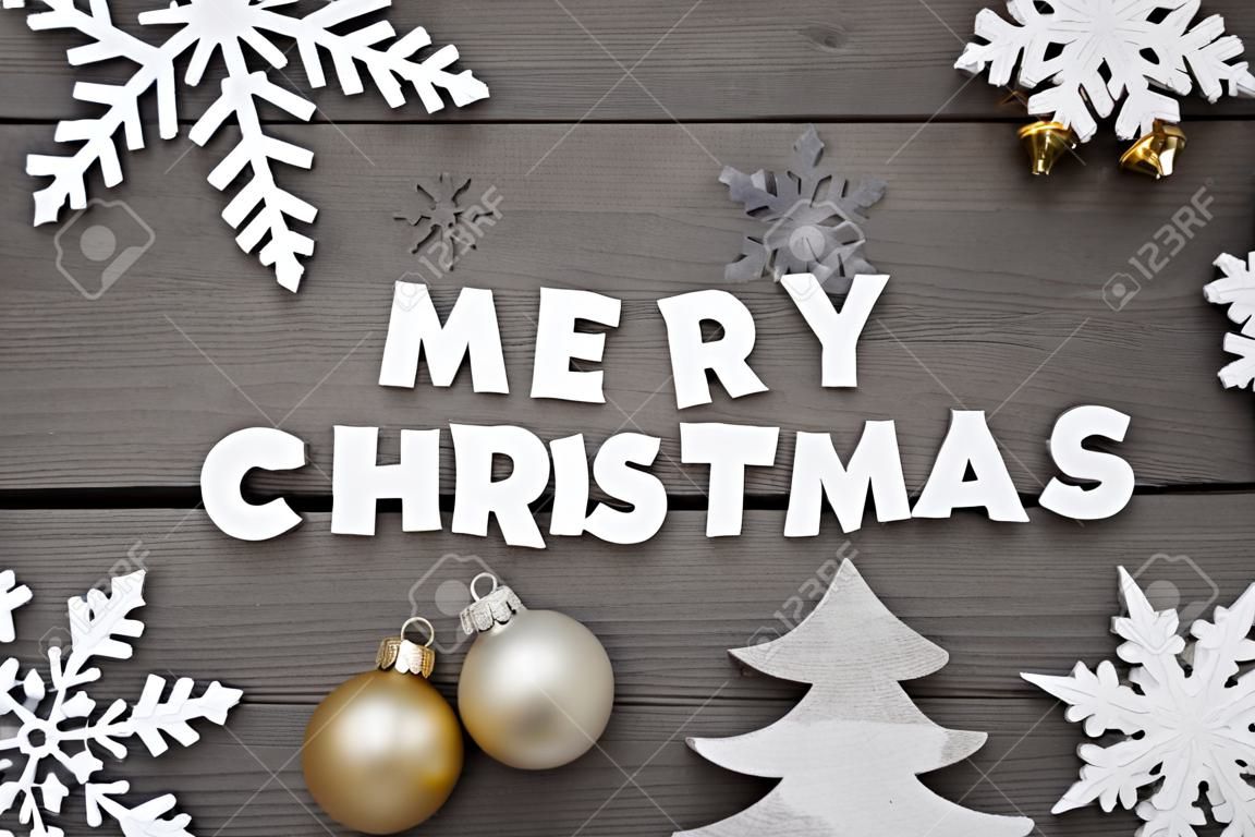 Fehér betűk a Word Boldog karácsonyt, barna fa háttér. Karácsonyi üdvözlőlap. Szürke rusztikus, vintage stílusú. Karácsonyi dekoráció, karácsonyfa, hópelyhek, Arany karácsonyi bál