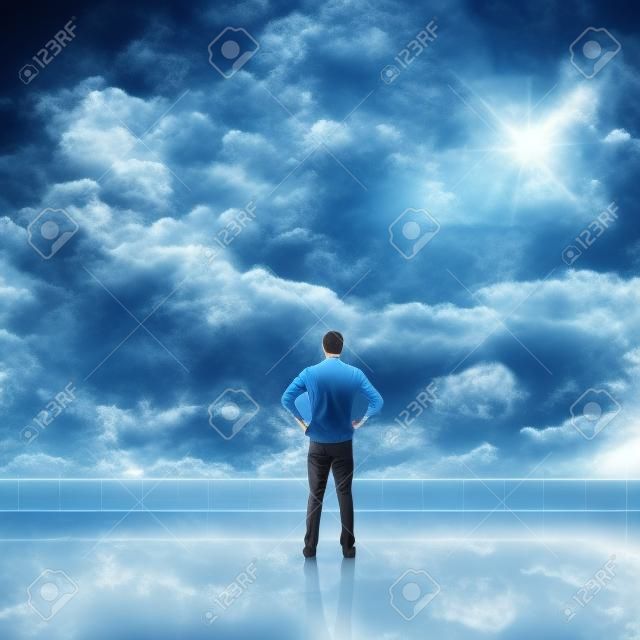 L'uomo guarda e scopre contro il cielo nuvoloso con copyspace.