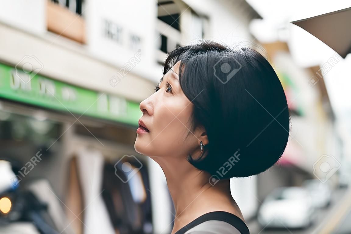mature Asian woman wait and see, concept of dream, hope, confident etc