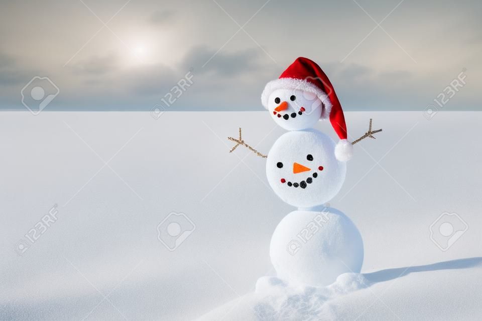 Homem de neve de areia sorridente no chapéu de santa. Conceito de férias para anos novos e cartões de Natal.