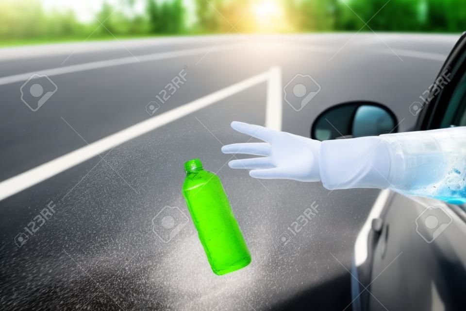 운전사가 도로의 차창에서 플라스틱 병을 버리고 있습니다. 환경 보전. 플라스틱 오염 개념