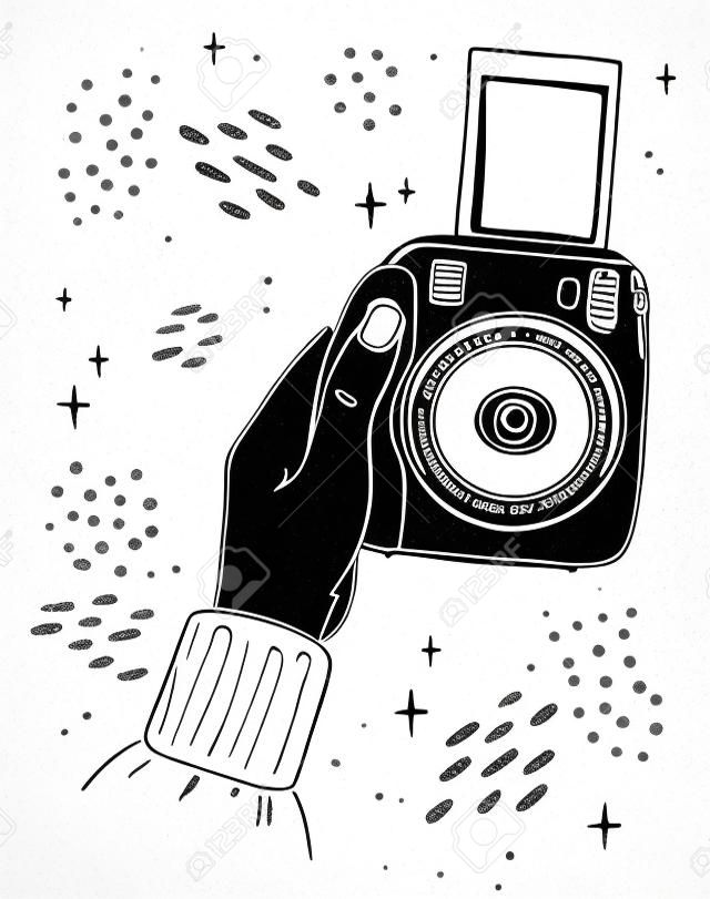 Illustration hand holds instant print camera. The picture goes out of the camera. Black outline on white background.