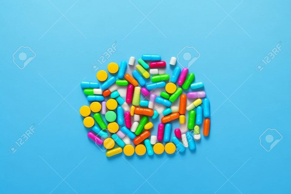 un gros tas de pilules colorées sur fond bleu