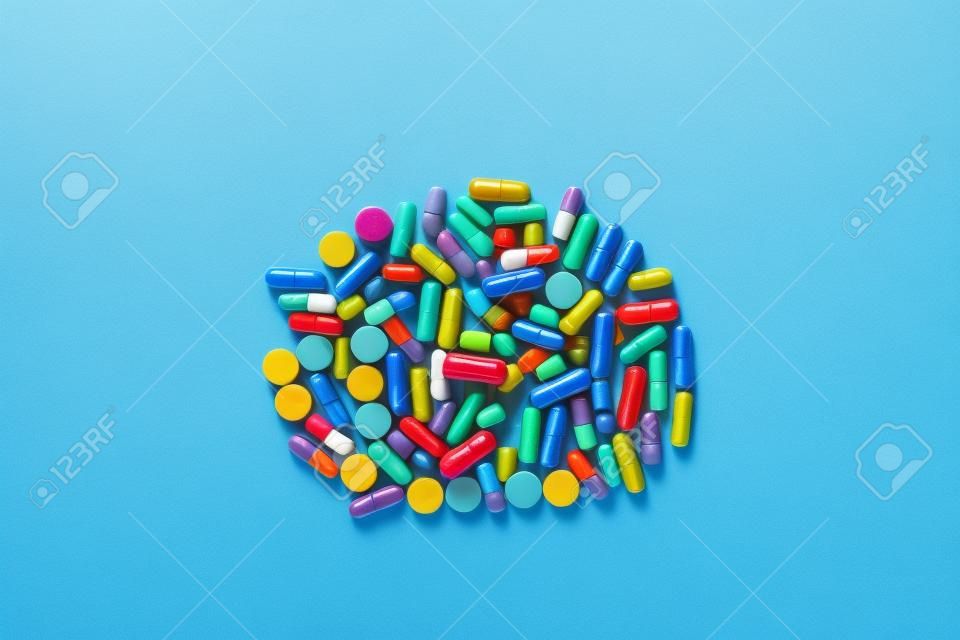 one big pile of colorful pills on a blue background