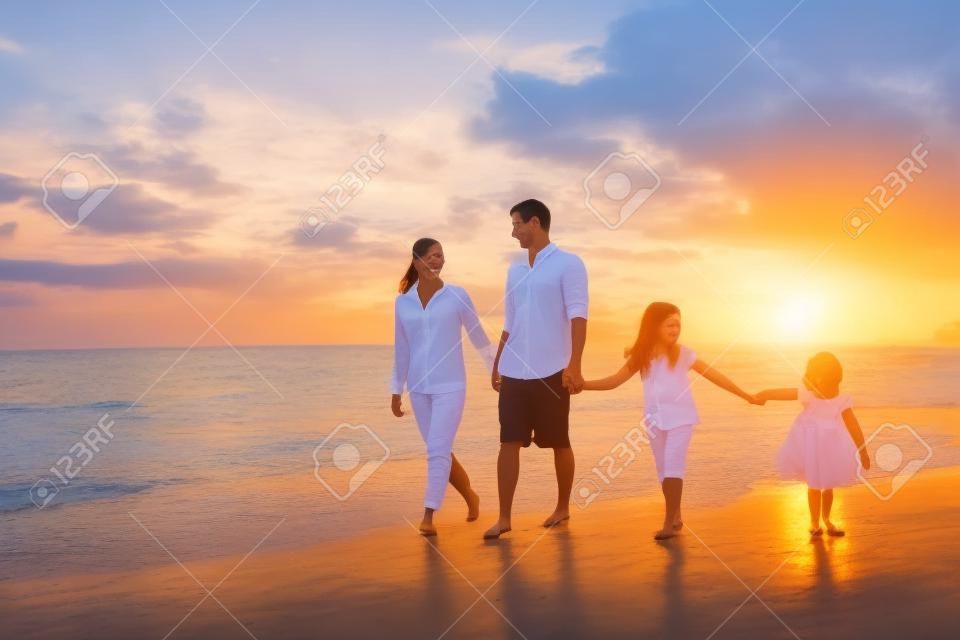 Glückliche junge Familie haben Spaß auf Strand am Sonnenuntergang
