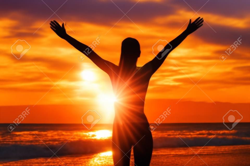 Gratis gelukkige vrouw open armen bij zonsondergang