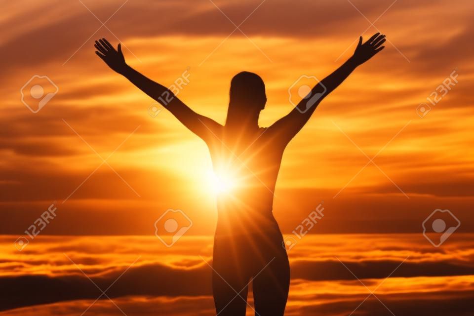 Free happy woman open arms at sunset