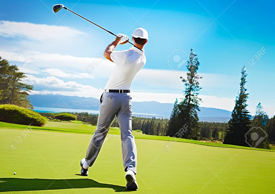 Golfer Hitting Ball with Club on Beautiful Golf Course 