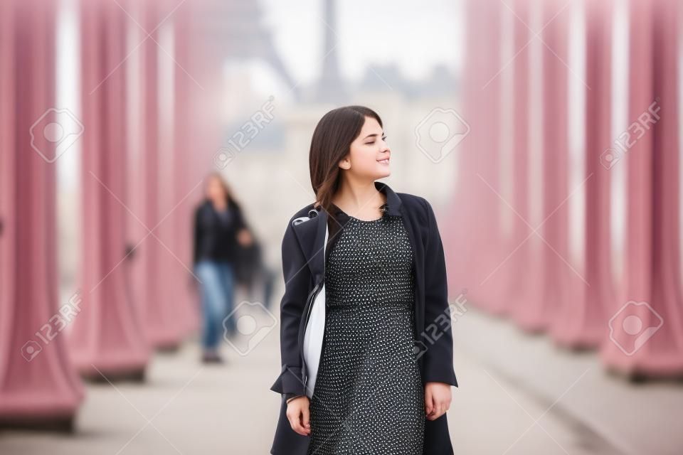 Beautiful young girl on Bir-Hakeim bridge on a fall or spring day. Paris, France