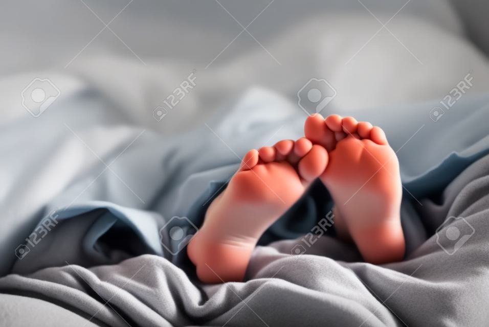 Niña durmiendo con los pies metiendo de mantas