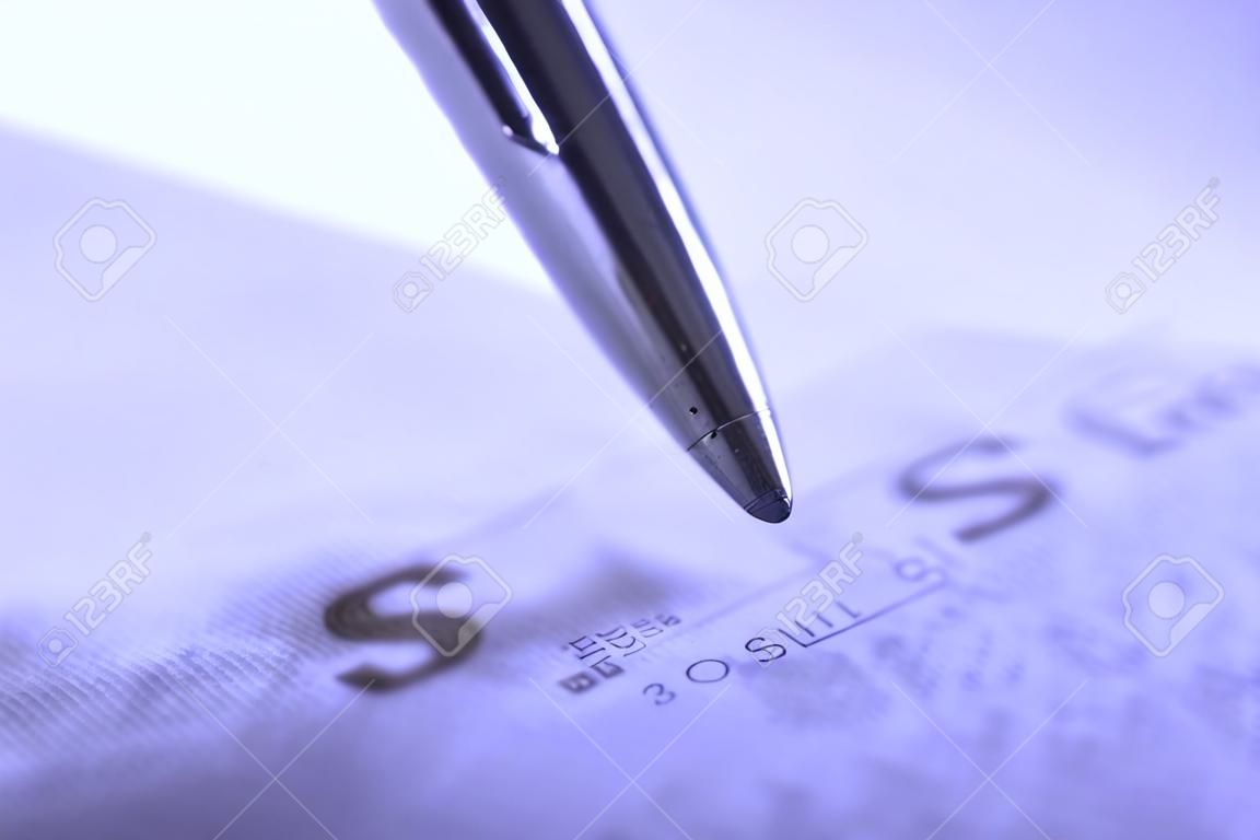 Person writing check with pen and checkbook