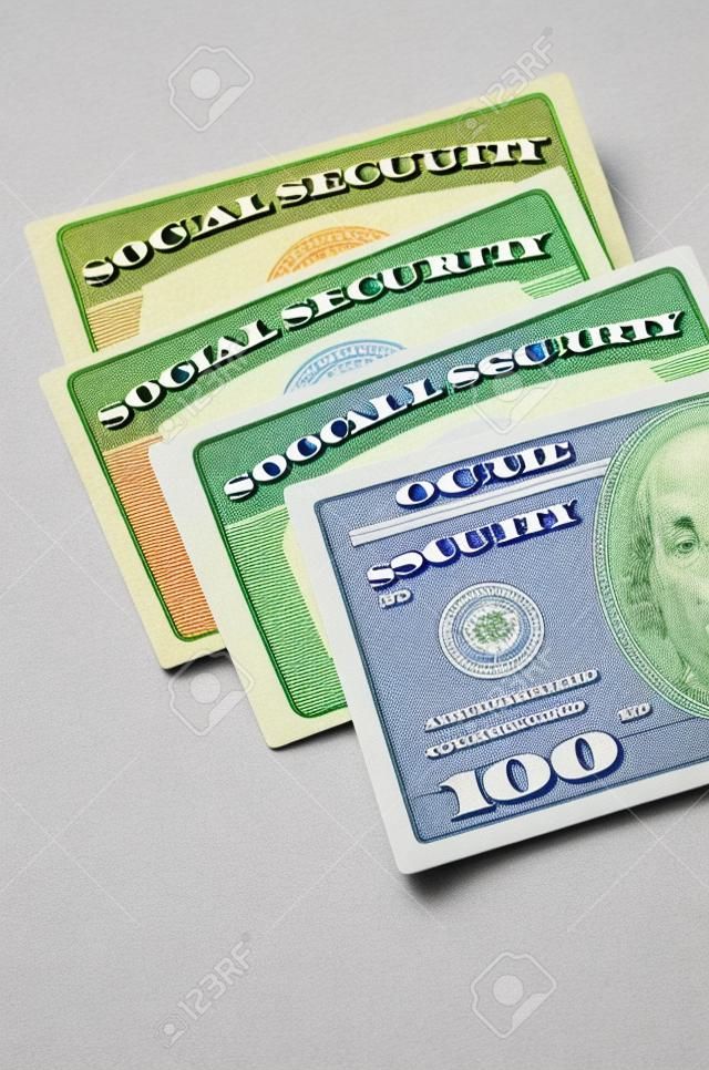 Detalle de varias tarjetas de Seguro Social y el dinero en efectivo que simboliza las pensiones de jubilación de seguridad financiera
