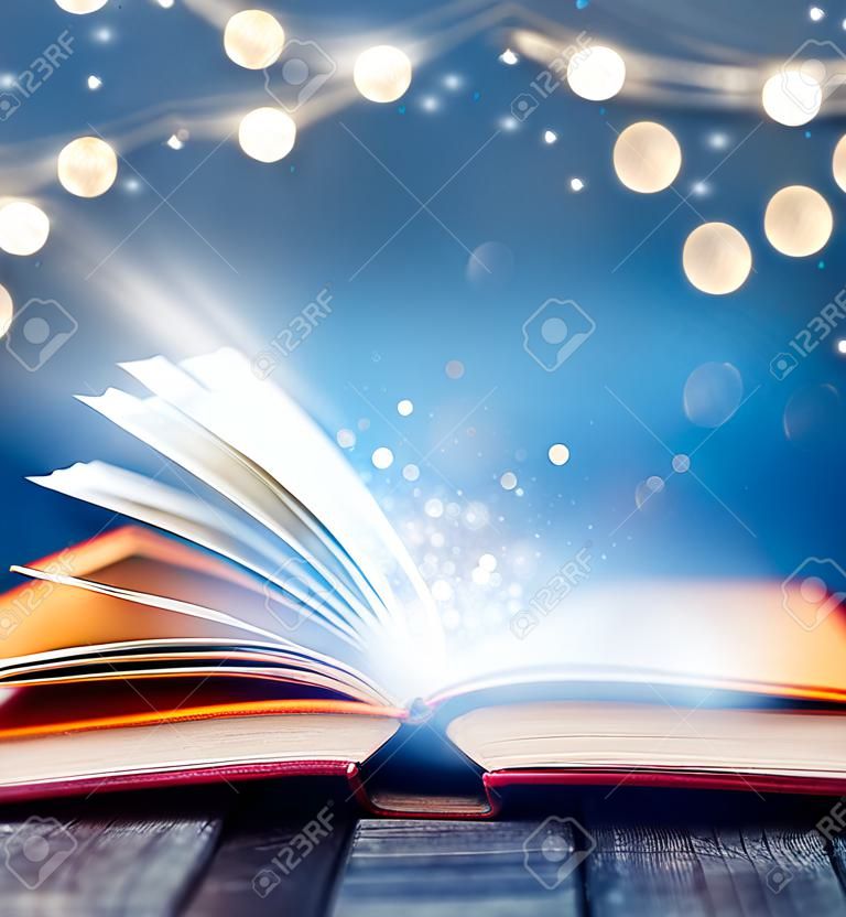 Offenes Buch mit magischen Lichtern. Konzept von Weisheit, Religion, Lesen, Fantasie, Winterferien