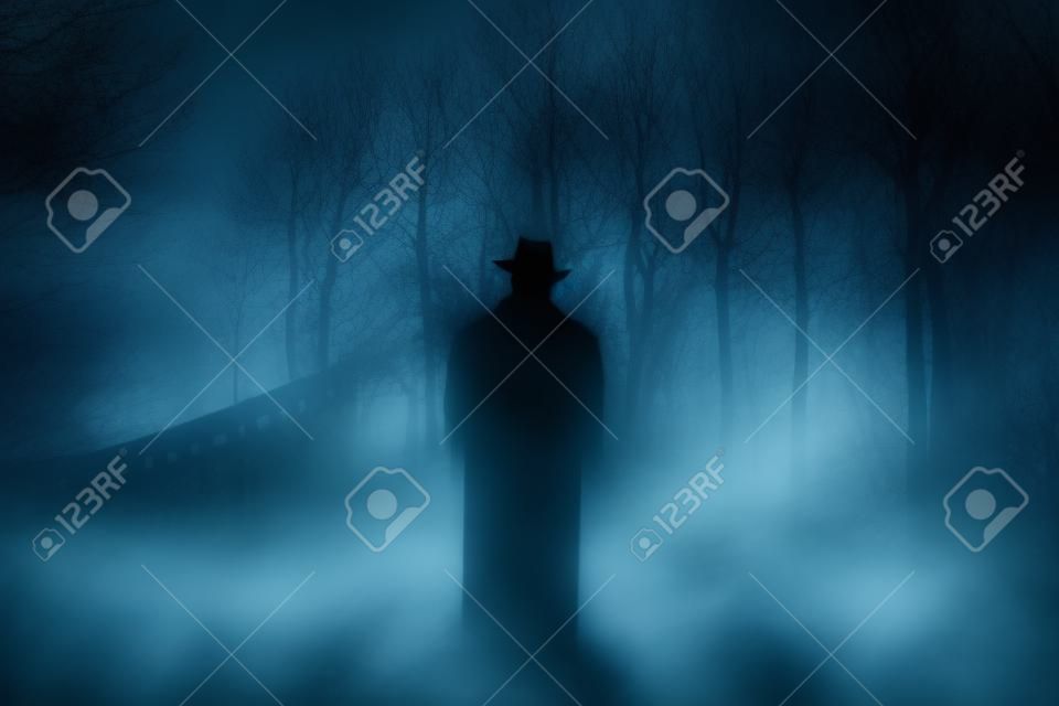 Arrière-plan d'horreur d'une figure fantomatique dans une forêt enchantée par une nuit sombre et brumeuse. Notion d'Halloween
